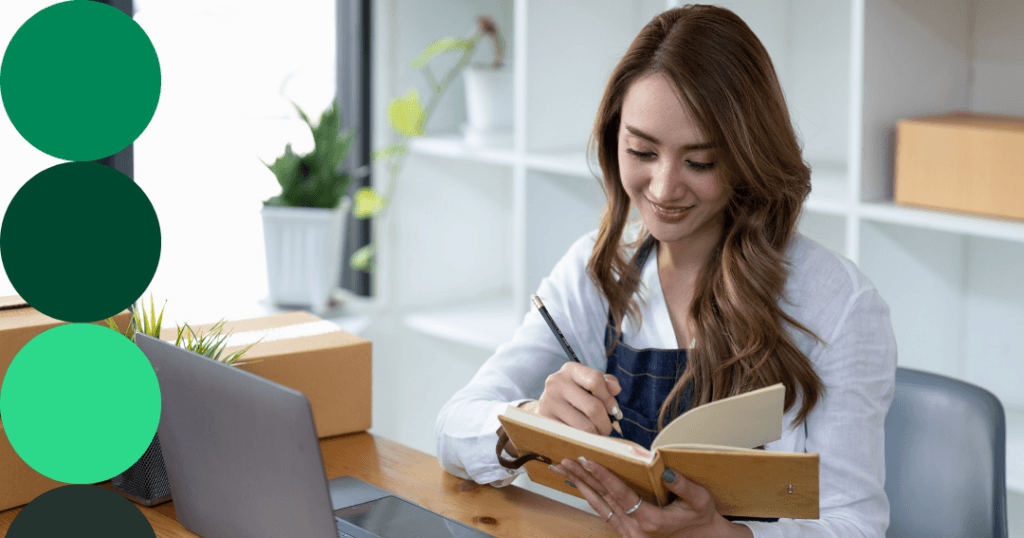 Woman sitting at her desk in front of her laptop looking at business documents.