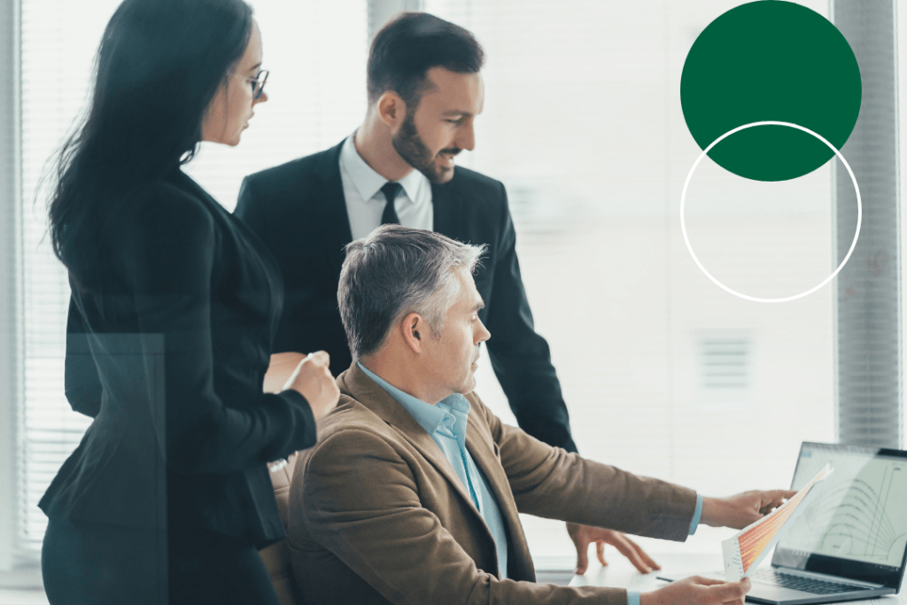 Three business professionals reviewing data reports and a laptop together in a corporate office setting, with dark green and white branded circle graphics overlaid in the top right corner.