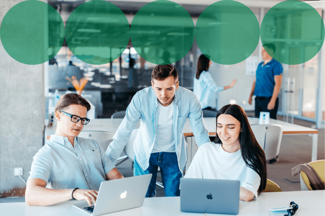Three colleagues collaborating around laptops in a bright, open-plan office, with a row of dark green branded circle graphics overlaid along the top of the image.