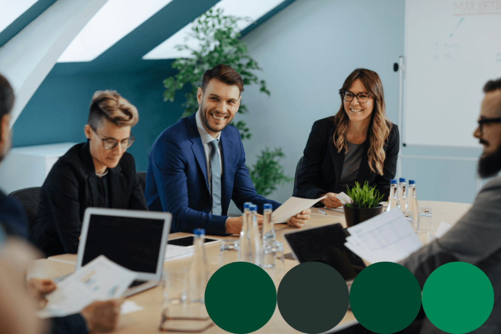 Procurement professionals collaborating around a conference table, reviewing documents and laptops during a supplier data strategy meeting.