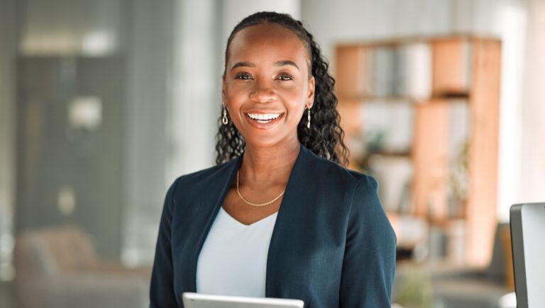 Supplier diversity leader smiling confidently while holding a tablet in a modern office