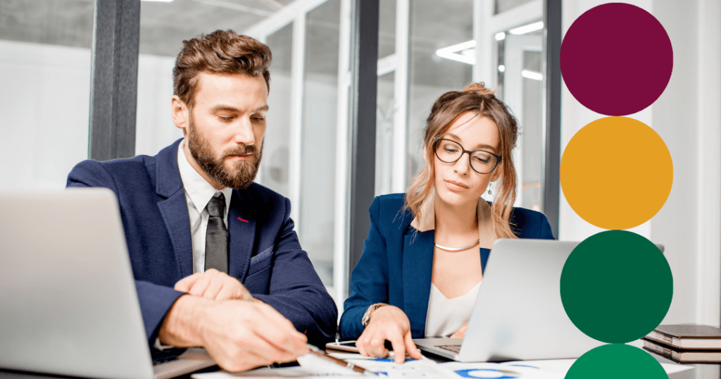 Two business professionals in navy blazers reviewing charts and data on laptops at a shared desk, with green branded circle graphics overlaid along the right edge.