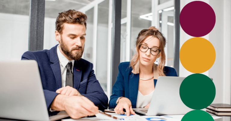 Two business professionals in navy blazers reviewing charts and data on laptops at a shared desk, with green branded circle graphics overlaid along the right edge.