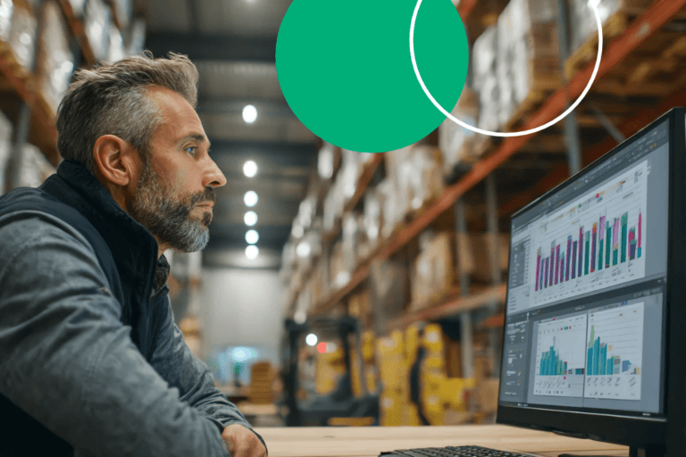 Procurement professional reviewing supplier data on a monitor in a warehouse