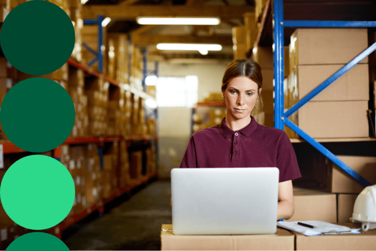 Procurement worker checking supplier spend data on a laptop in a warehouse
