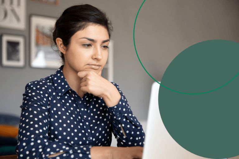 Woman working on her laptop, looking pensively at the screen.